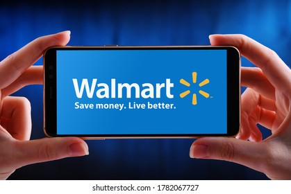 POZNAN, POL - MAY 21, 2020: Hands holding smartphone displaying logo of Walmart Inc., an American multinational retail corporation headquartered in Bentonville, Arkansas