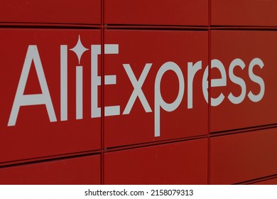 Poznan, Poland. 19 May 2022: Close-u sign AliExpress red locker, called paczkomat, an automated parcel collection drop box with a board. Logotyp.