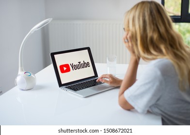 Poznan, Poland, 3.09.2019. Young Woman Using Laptop With YouTube Logo In The Screen Seeting At The Office Desk. A Girl In Office Watching You Tube. 