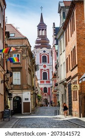 Poznan, Poland - August 09, 2021. Street heading to Basilica of Our Lady of Perpetual Help, Mary Magdalene and St. Stanislaus with LGBT flags in window