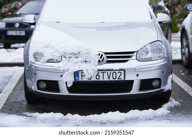 POZNAN, POLAND - Dec 05, 2021: A front view of a parked grey Volkswagen Golf car covered in snow in winter