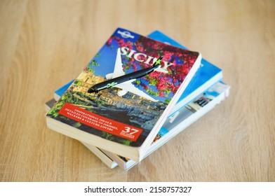 POZNAN, POLAND - Feb 20, 2022: A Toy Model Passenger Plane On A Travel Guide About Sicily On A Table 