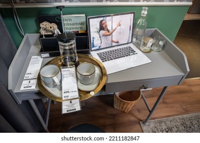 POZNAN, POLAND - Jun 13, 2022: A Small Exposition Desk With Cups, Bottle And Laptop In An IKEA Furniture And Home Appliance Store