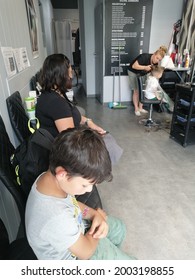 POZNAN, POLAND - Jun 26, 2021: Woman And Child Waiting For Their Turn At A Hair Dresser