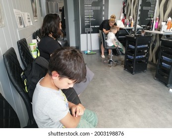 POZNAN, POLAND - Jun 26, 2021: Woman And Child Waiting For Their Turn At A Hair Dresser