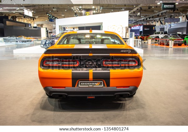 Poznan, Poland, March\
28, 2019: metallic orange Dodge Challenger SRT Hellcat at Poznan\
International Motor Show, Third generation, muscle car manufactured\
by Dodge