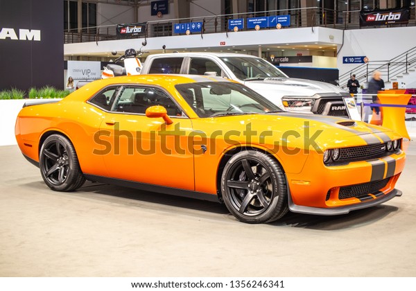 Poznan, Poland, March\
28, 2019: metallic orange Dodge Challenger SRT Hellcat at Poznan\
International Motor Show, Third generation, muscle car manufactured\
by Dodge