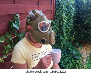 Poznan - Poland / September 14 2019, Prepper Woman Wearing Military Gas Mask Is Having A Coffee In A Yellow T-shirt Saying “not Today” As Symbol That She Is Ready To Fight For Survival