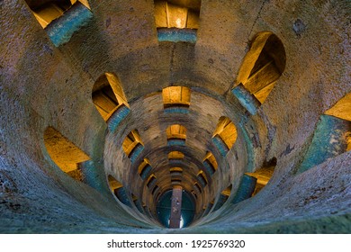 Pozzo di San Patrizio, a Renaissance historic water well built by Sangallo, with a cylinder shaft surrounded by a double helix spiral staircase and arch windows in Orvieto medieval city, Umbria, Italy