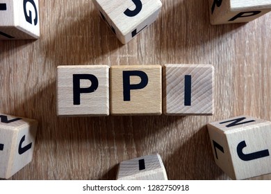 PPI word (Payment Protection Insurance) from wooden blocks on 
desk