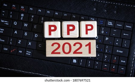 PPP 2021 Concept. Wooden Cubes On A Black Keyboard