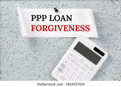 PPP LOAN FORGIVENESS Text On Grey Cork Notice Board With Calculator. Small Business Paycheck Protection Program. Banking And Finance Concept