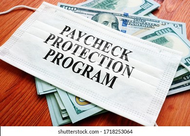 PPP Paycheck Protection Program as SBA loan written on the mask and money. - Shutterstock ID 1718253064