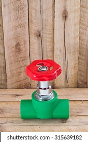 PPR valve with red on wooden table background