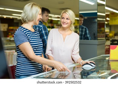 Practical Women 55-60 Years Old Choosing Frozen Meat In Food Store