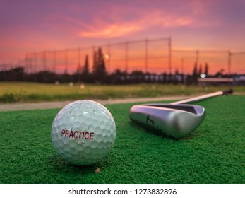 Practice Golf Ball With Golf Club In Driving Range With Dramatic Sky During Sun Set, Photo Taken By Mobile Phone