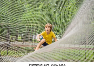 Practice Nets Playground. Boy Plays In The Playground Shielded With A Protective Safety Net. Concept Of Children On Line, Kid In Social Networks. Blurred Background, Blurred Motion Due To The Concept