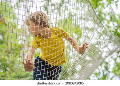 practice nets playground. boy plays in the playground shielded with a protective safety net. concept of children on line, kid in social networks. blurred background, blurred motion due to the concept - Powered by Shutterstock