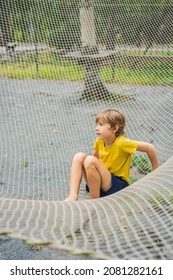 Practice Nets Playground. Boy Plays In The Playground Shielded With A Protective Safety Net. Concept Of Children On Line, Kid In Social Networks. Blurred Background, Blurred Motion Due To The Concept