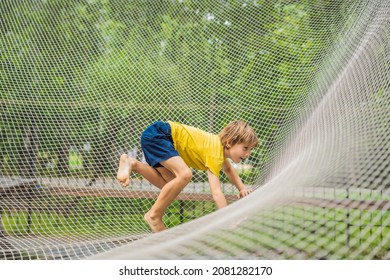 Practice Nets Playground. Boy Plays In The Playground Shielded With A Protective Safety Net. Concept Of Children On Line, Kid In Social Networks. Blurred Background, Blurred Motion Due To The Concept