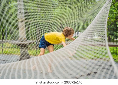 Practice Nets Playground. Boy Plays In The Playground Shielded With A Protective Safety Net. Concept Of Children On Line, Kid In Social Networks. Blurred Background, Blurred Motion Due To The Concept