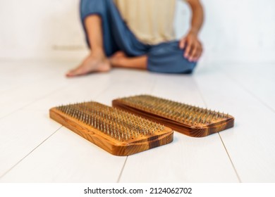 Practice of standing on nails. Man sitting in the background. Wooden sadhu board with nails for sadhu practice