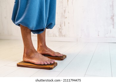 Practice of standing on nails. Sadhu wooden board with nails for sadhu practice. A man stands on nails on a light background