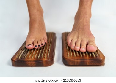 Practice of standing on nails. Sadhu wooden board with nails for sadhu practice. Female and male feet stand on a board with nails