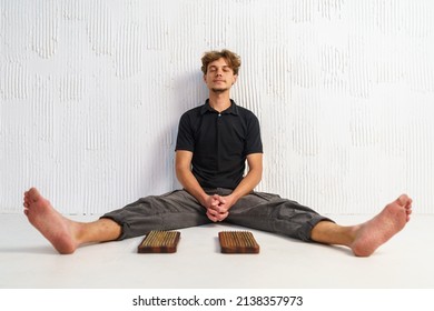 Practice of standing on nails. Sadhu wooden board with nails for sadhu practice. Young guy resting after practice sitting on the floor