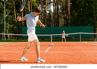 Practicing with friend. Full length of man and woman playing tennis on tennis court  - Powered by Shutterstock