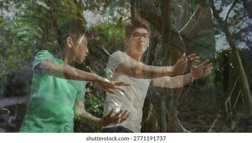 Practicing man, boy doing slow arm moves in forest, trees, dappled light, glasses, tees. Taichi, martialarts, overlay, ghosted, woodland, clearing, canopy