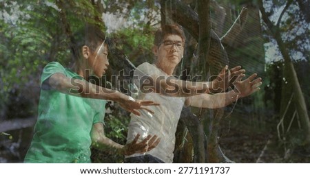 Practicing man, boy doing slow arm moves in forest, trees, dappled light, glasses, tees. Taichi, martialarts, overlay, ghosted, woodland, clearing, canopy