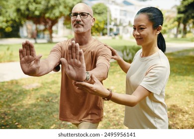 Practicing Tai Chi With Instructor in Public Park Setting - Powered by Shutterstock