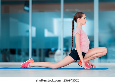 Practicing Yoga. Beautiful Teenage Girl In Sports Clothing Training Yoga Position On The Mat In Health Club