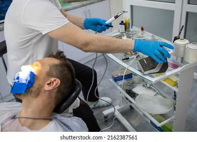 Practitioner Male Dentist Drilling Tooth To Patient In Dental Studio