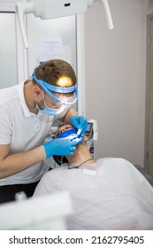 Practitioner Male Dentist Drilling Tooth To Patient In Dental Studio