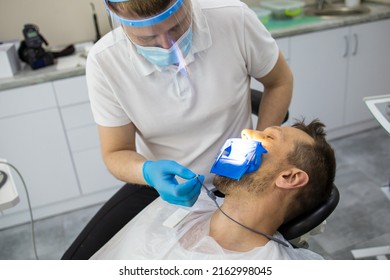 Practitioner Male Dentist Drilling Tooth To Patient In Dental Studio