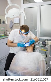 Practitioner Male Dentist Drilling Tooth To Patient In Dental Studio