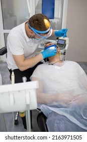 Practitioner Male Dentist Drilling Tooth To Patient In Dental Studio