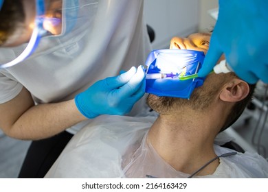 Practitioner Male Dentist Drilling Tooth To Patient In Dental Studio