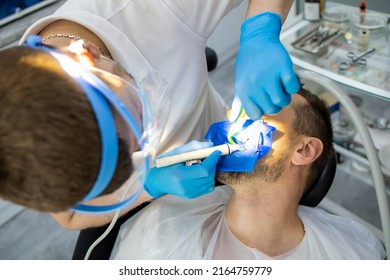 Practitioner Male Dentist Drilling Tooth To Patient In Dental Studio