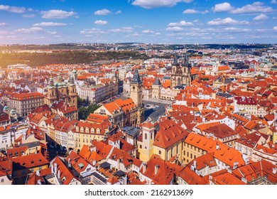Prague beautiful panoramic sunny aerial drone view above Prague Old Town Square with Church of Our Lady before Tyn and Prague Astronomical Clock Tower. Drone flight over red roofs of Prague, Czechia.
