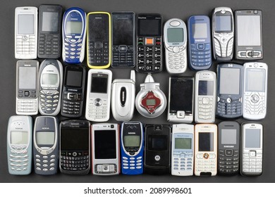 Prague, CZ -  12 December 2021:  A lot of old used mobile phones with keyboards, Various brands. Many types and generations of mobile smartphone gadgets in row. Editorial