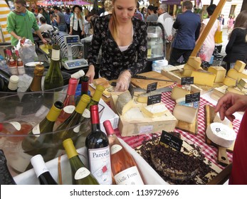 Prague / Czech Republic - 07 14 2017: Cutting A Variety Of Very Tasty Cheeses Is Made For Sale Under A Glass Of Wine Right On The Street In The Spontaneous Market Area, Organized Under Umbrellas