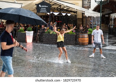 Prague - Czech Republic - 08 01 2020: Happy adult woman splashing in the rain puddles