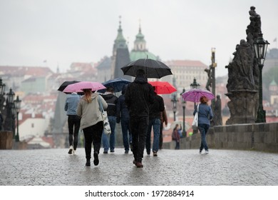 Prague, Czech Republic - 12.5.2021: People Walking With Umbrellas On Charles Bridge