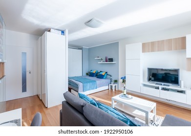 PRAGUE, THE CZECH REPUBLIC, 17.8.2020 - Small cozy studio apartment with cozy bed,sofa, blue and white wall, wooden floor.