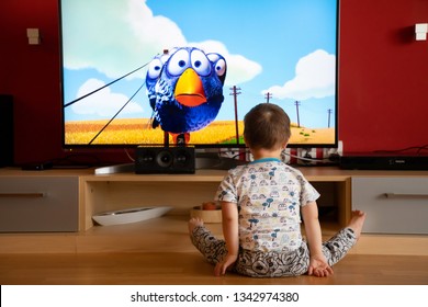 Prague, Czech Republic -18.03.2019: Small Boy With Down Syndrome Watching Cartoon On TV