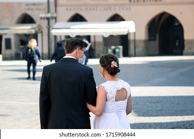 Prague, Czech Republic - April 23, 2020: Wedding Couple In Medical Face Masks In The Old Town. Wedding During Coronavirus Pandemic. COVID-19 Weddings. Horizontal Photo.