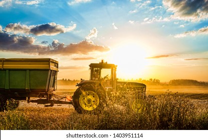 Prague, Czech Republic - August 14, 2013. Tractor harvesting grain during summer sunset in Czech Republic